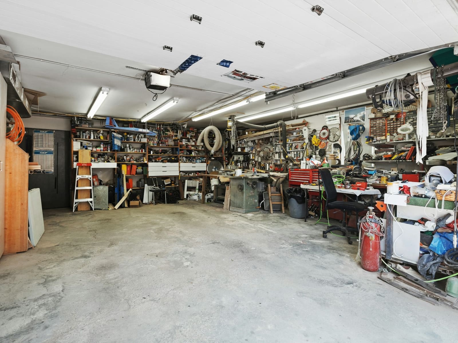 Garage after a cleanout: floor clear and swept, everything up on shelves and benches