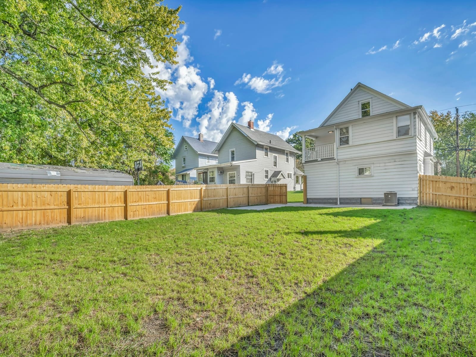 Backyard after a shed removal: ground cleared, lawn tidy, fence line open