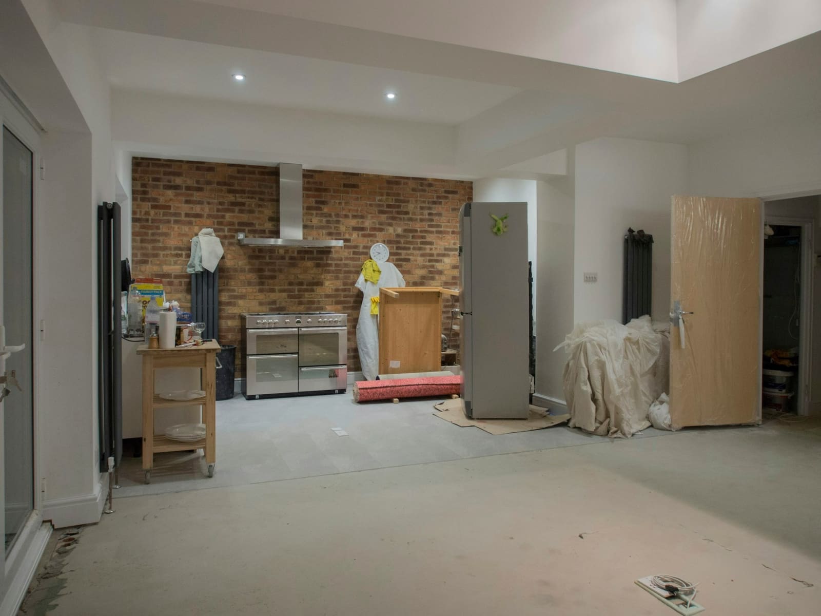 Kitchen mid-tear-out with exposed brick, stripped back and ready for renovation